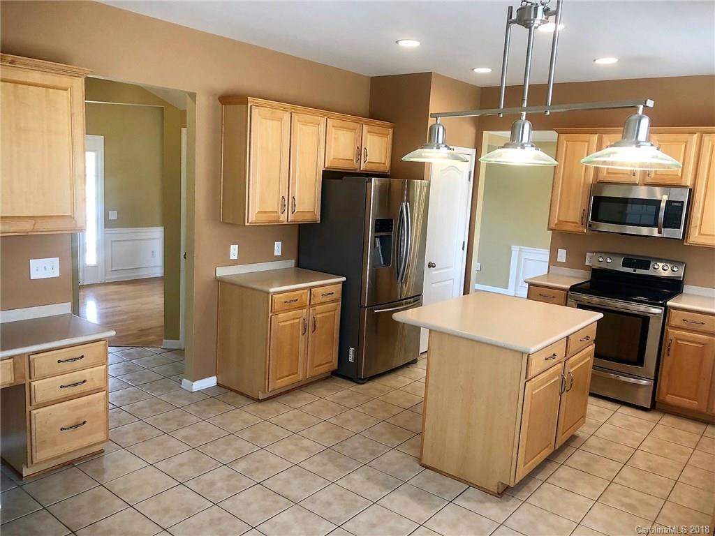 2401 Coltsgate Road Waxhaw, NC 28173 - Photo 7 of 22 a kitchen filled with white cabinets and stainless steel appliances