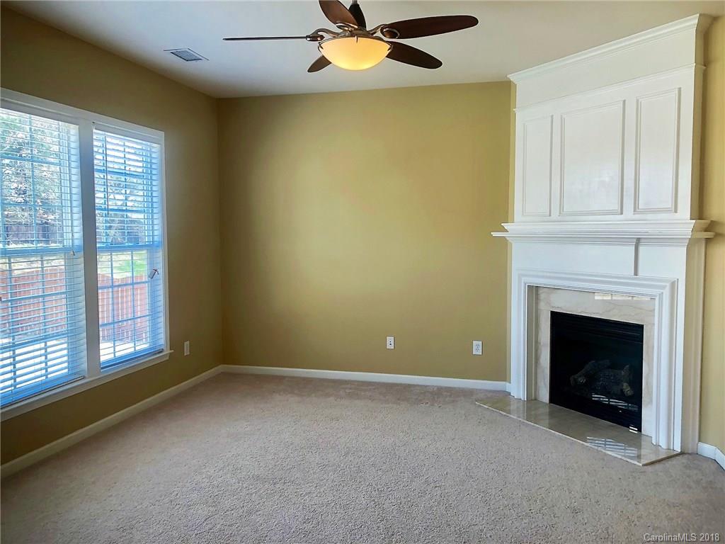 2401 Coltsgate Road Waxhaw, NC 28173 - Photo 9 of 22 a view of an empty room with a fireplace and a window