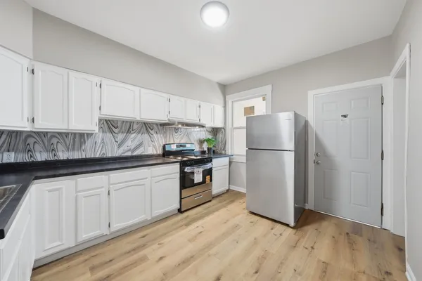 a kitchen with white cabinets and white appliances