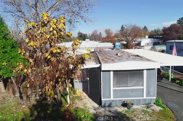 a view of a house with a yard and potted plants