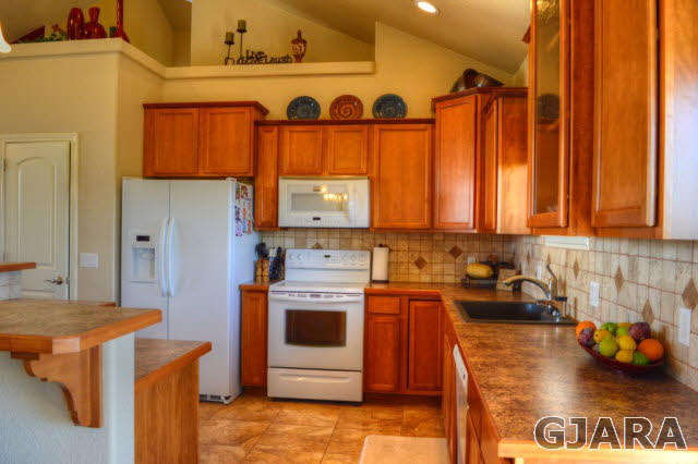 1575 15 Road Loma, CO 81524 - Photo 7 of 30 a kitchen with stainless steel appliances granite countertop a stove a sink and a refrigerator