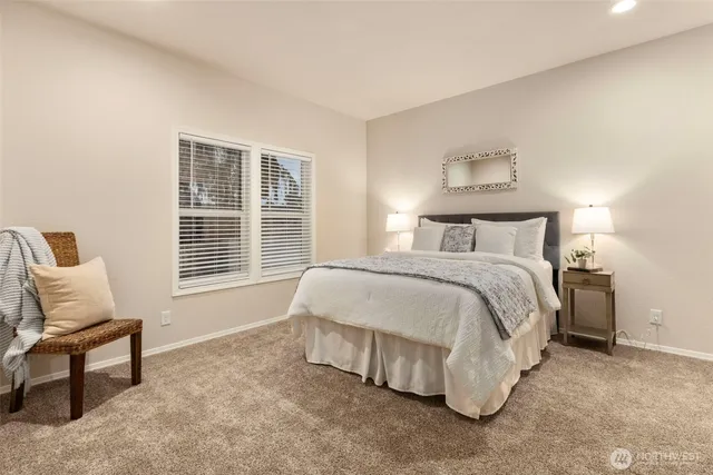 a spacious bedroom with a bed and chair