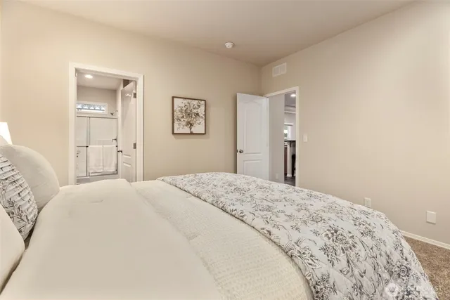 a bedroom with a bed and painting on the wall