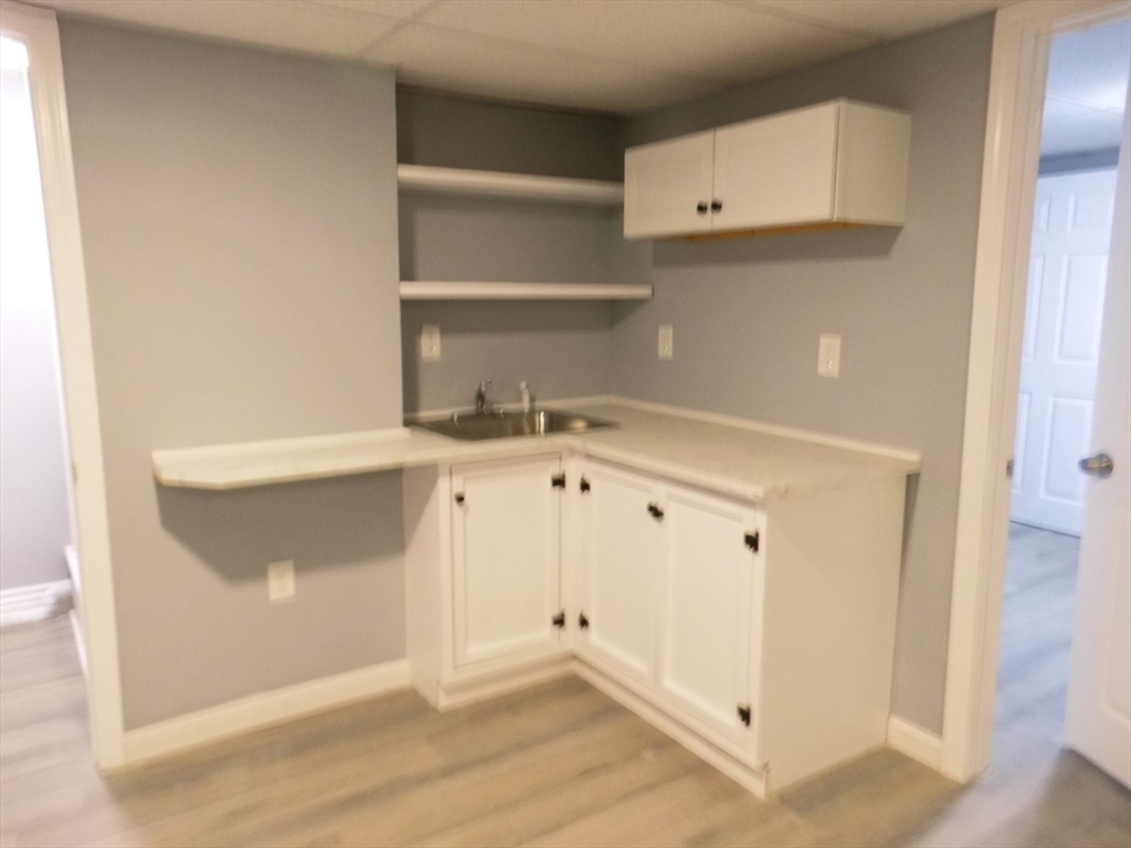 13 Showell Pond Road Sandown, NH 03873 - Photo 35 of 42 a view of cabinets and utility room with wooden floor