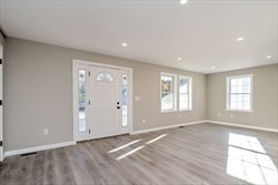 13 Showell Pond Road Sandown, NH 03873 - Photo 7 of 42 an empty room with wooden floor and windows