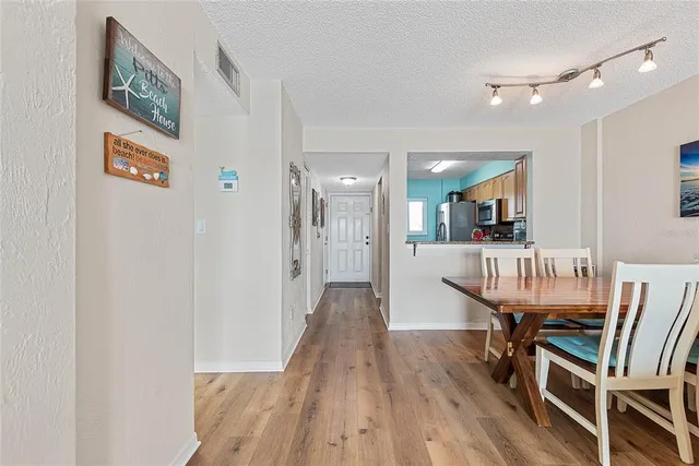 a view of a hallway with wooden floor and chairs