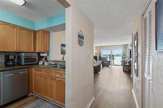 a view of a kitchen with kitchen island wooden floors appliances and furniture