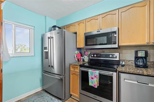 a kitchen with stainless steel appliances granite countertop a refrigerator stove and microwave