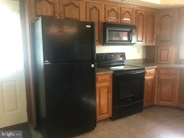 a kitchen with granite countertop cabinets and refrigerator