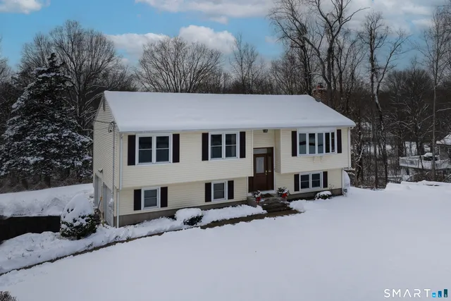 a front view of a house with a yard covered in snow