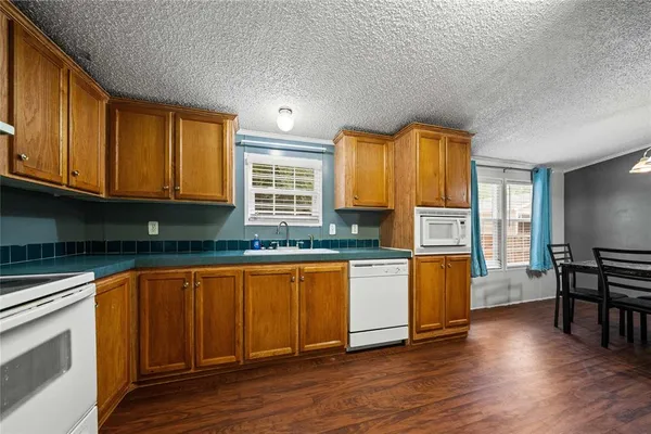 a kitchen with stainless steel appliances granite countertop a refrigerator oven a stove with wooden floors