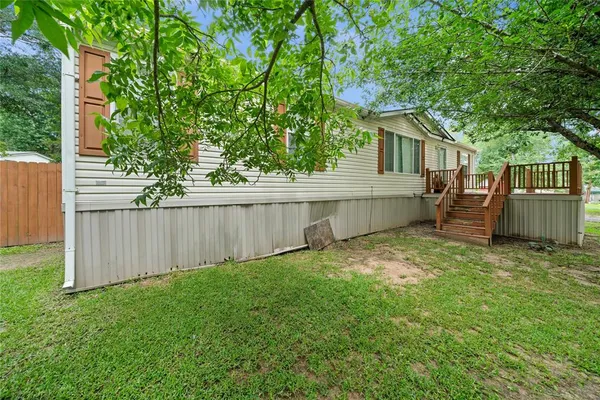 a view of a backyard with a large tree and wooden fence
