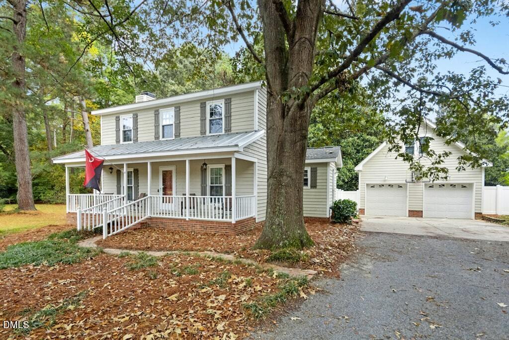 106 Village Court Garner, NC 27529 - Photo 3 of 38 a front view of a house with a garden and trees