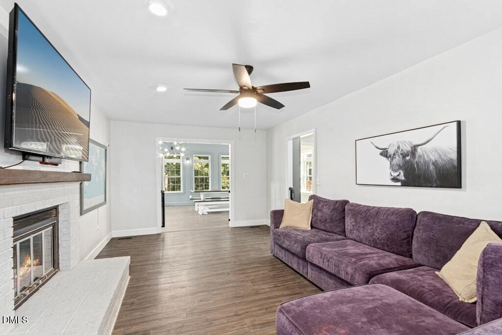 106 Village Court Garner, NC 27529 - Photo 6 of 38 a living room with furniture a fireplace and a flat screen tv