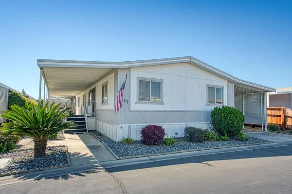 a view of a house with backyard and sitting area