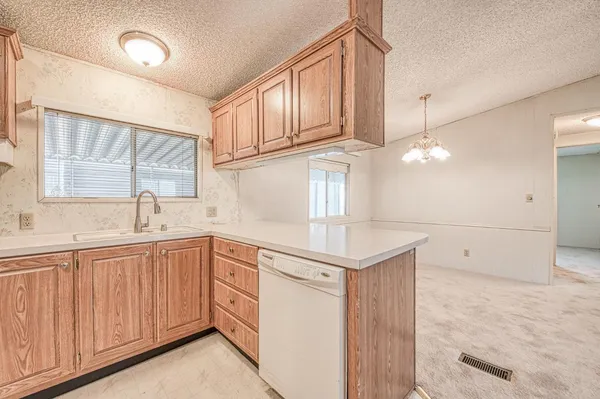 a kitchen with a sink dishwasher and cabinets