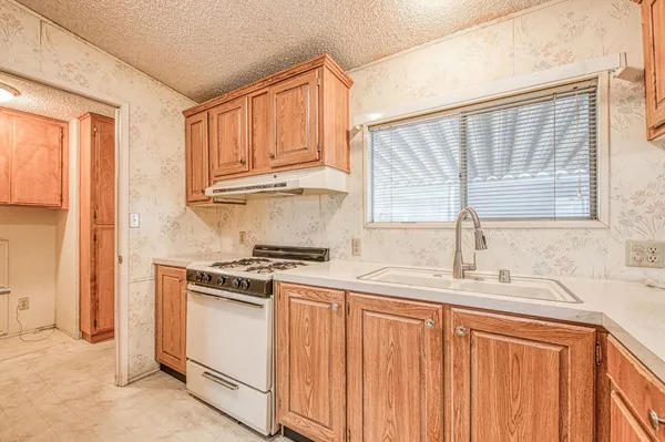 a kitchen with granite countertop cabinets stainless steel appliances a sink and a window