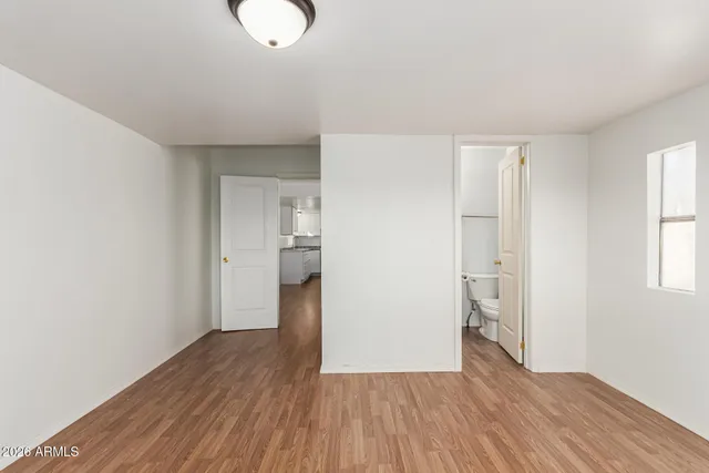 a view of empty room with wooden floor