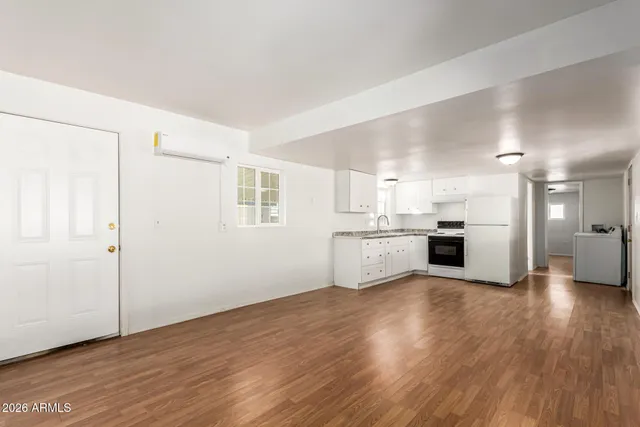 a view of a kitchen with a sink stove cabinets and empty room
