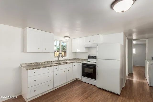 a kitchen with a white cabinets stainless steel appliances and wooden floor