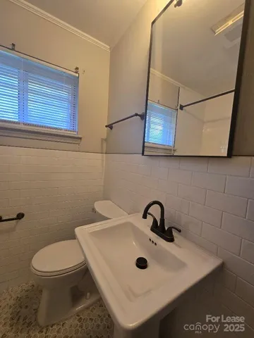 a bathroom with a sink a toilet and mirror
