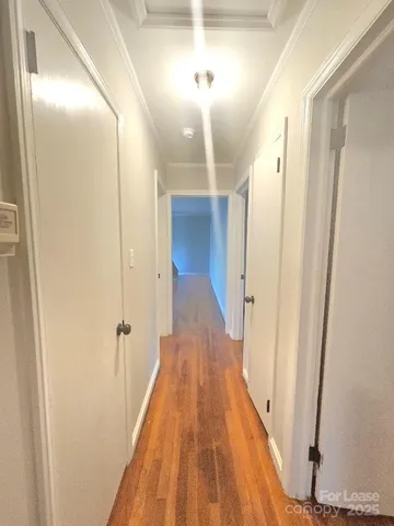 a view of a hallway with wooden floor and staircase