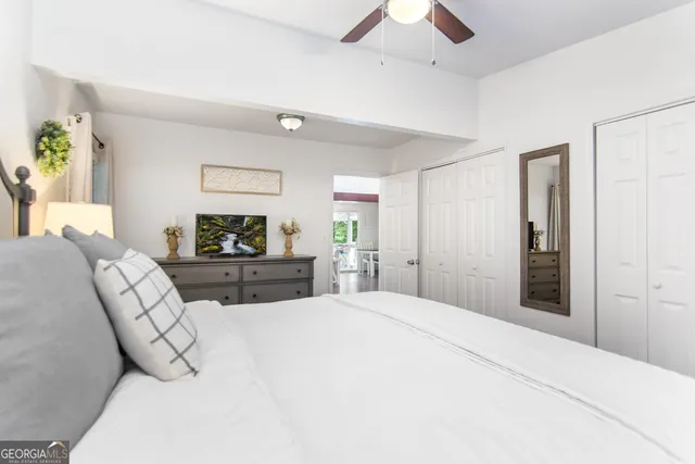 a large bedroom with a bed and a flat tv screen