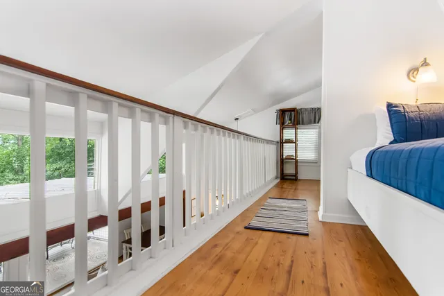a view of a hallway with wooden floor and staircase