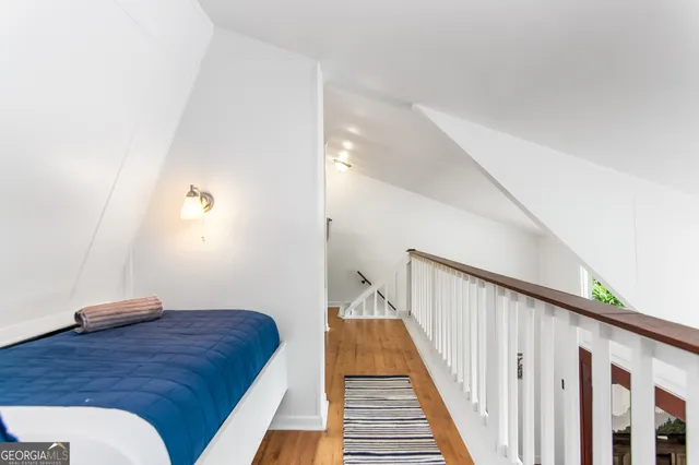 a view of a hallway with wooden floor and staircase
