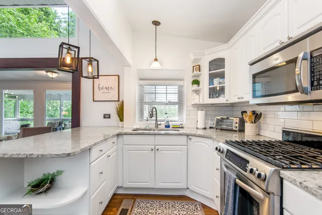 a kitchen with stainless steel appliances granite countertop a stove a sink and a microwave