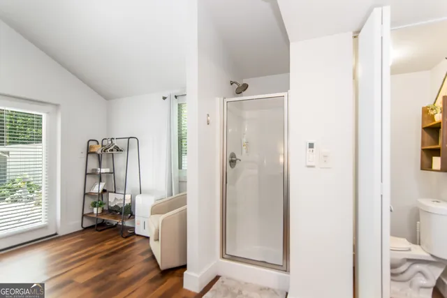 a view of a hallway with bathroom and wooden floor