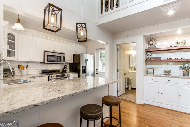 a kitchen with stainless steel appliances granite countertop a sink a stove counter space and cabinets