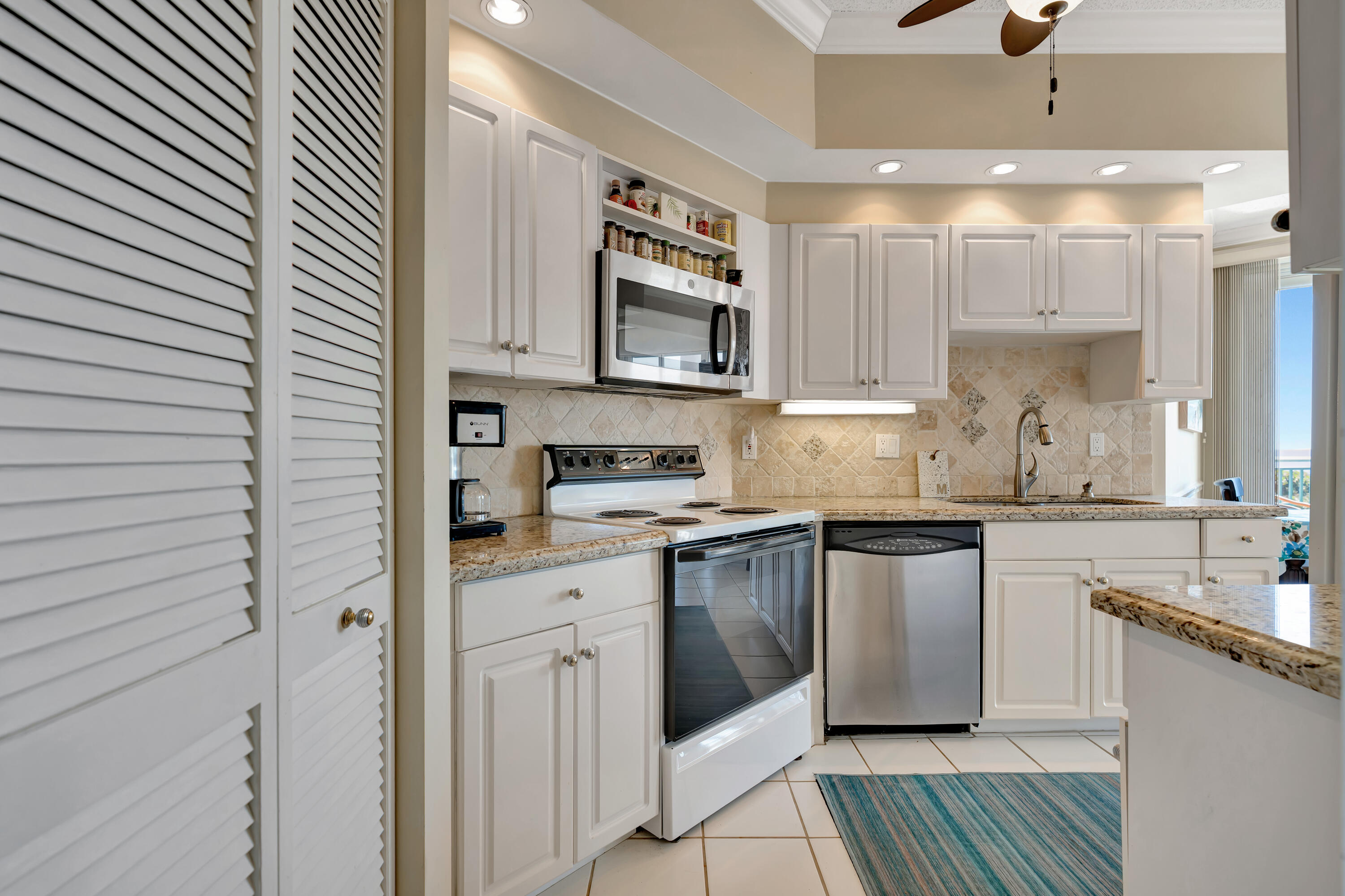 2000 Florida A1A, Unit N302 Jupiter, FL 33477 - Photo 28 of 65 a kitchen with stainless steel appliances granite countertop a sink a stove and cabinets