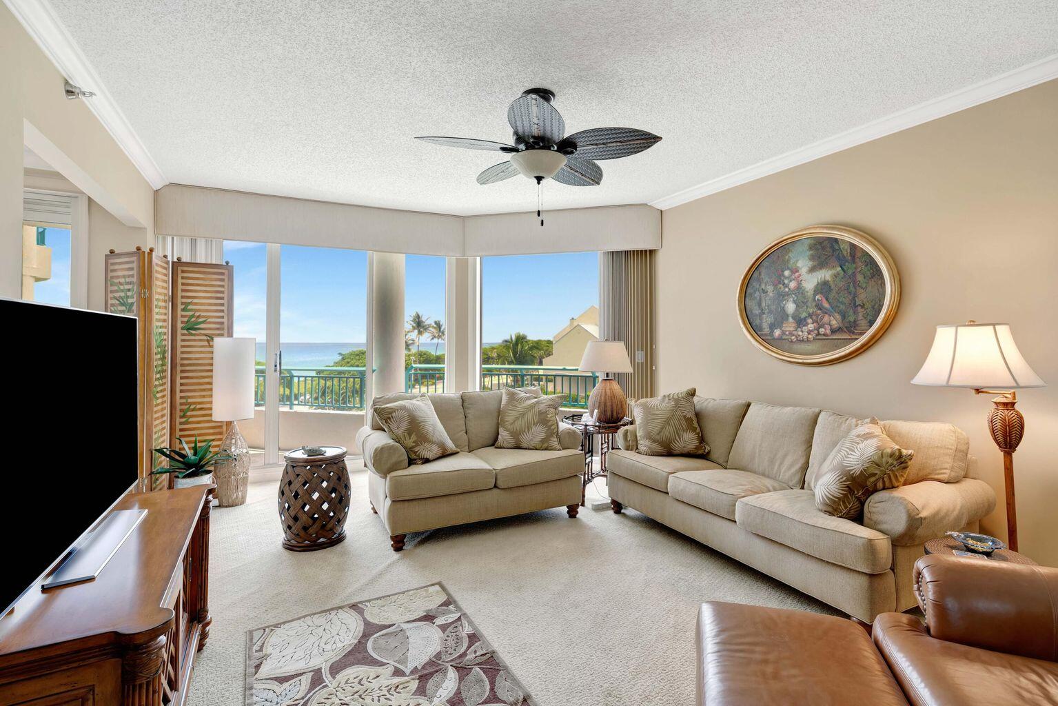 2000 Florida A1A, Unit N302 Jupiter, FL 33477 - Photo 51 of 65 a living room with furniture a large window and a flat screen tv