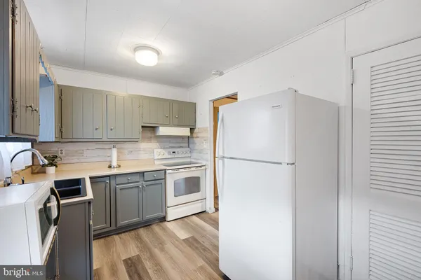 a kitchen with a sink a refrigerator a stove and cabinets