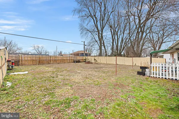 a view of a yard with wooden fence