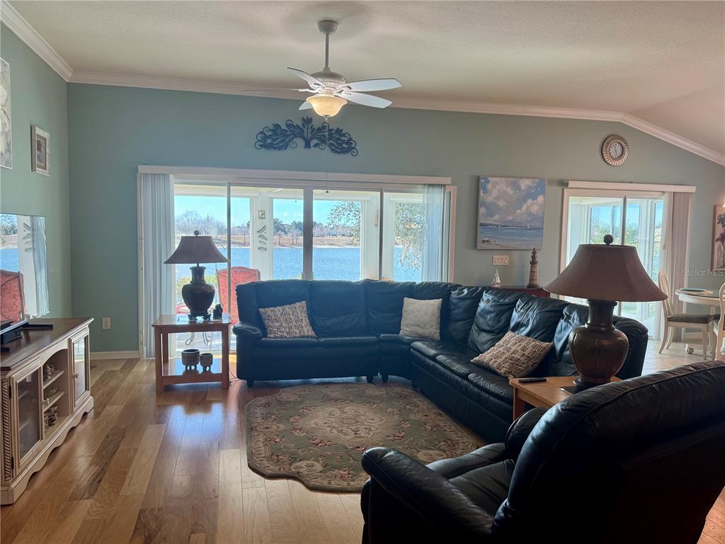 3436 Countryside Path The Villages, FL 32163 - Photo 4 of 31 a living room with furniture a chandelier and a flat screen tv
