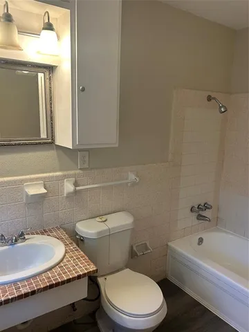 a bathroom with a granite countertop toilet a sink and a bathtub