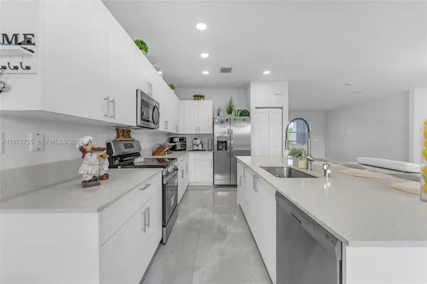 a kitchen with counter top space a sink stainless steel appliances and cabinets