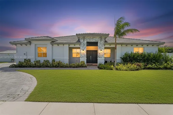 a front view of a house with a garden and yard