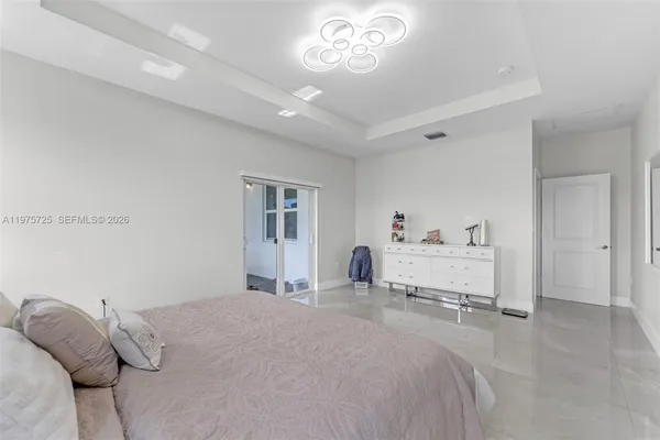 a bedroom with a bed and a chandelier