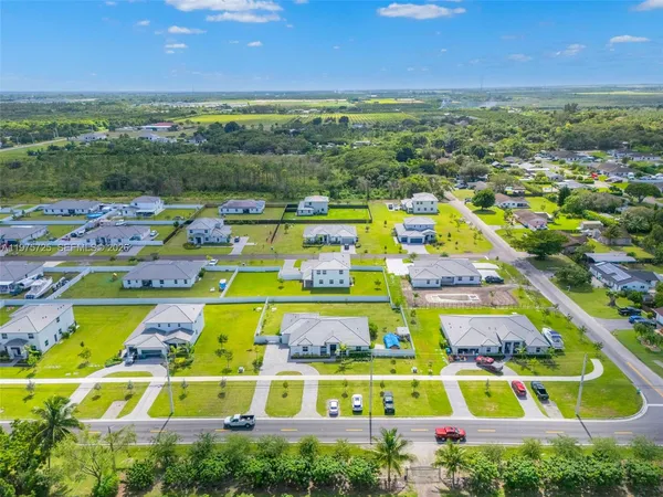 an aerial view of residential houses with outdoor space and a lake view