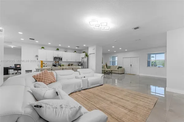 a living room with furniture and a view of kitchen