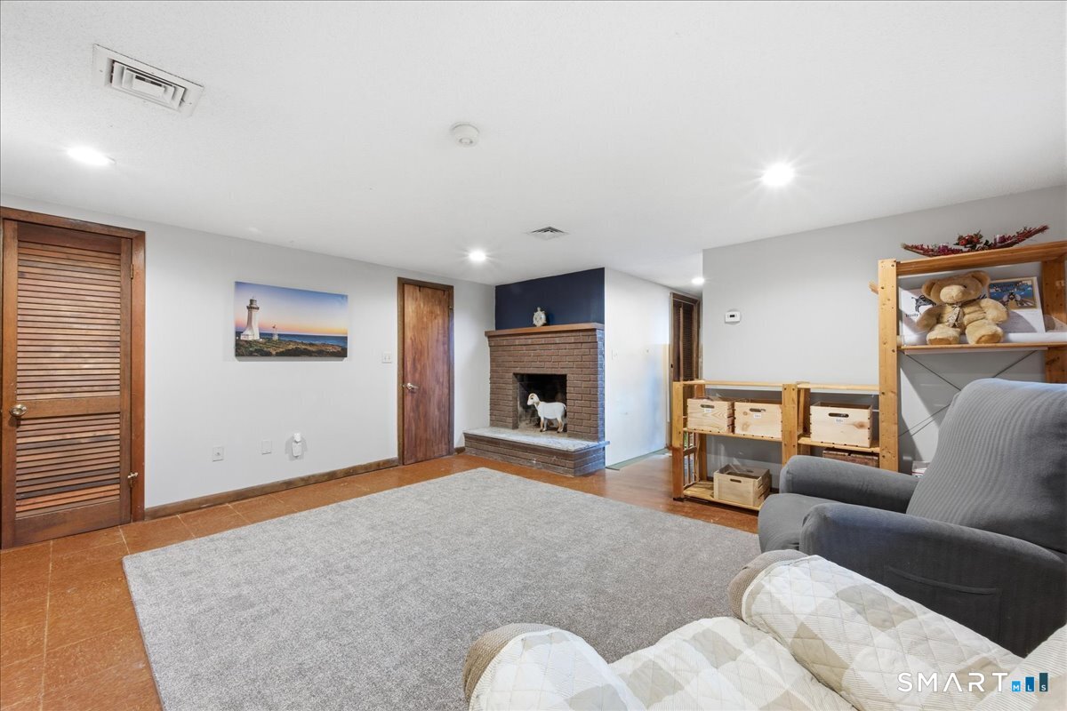 110 Butlertown Road Waterford, CT 06385 - Photo 19 of 35 a living room with furniture and a fireplace