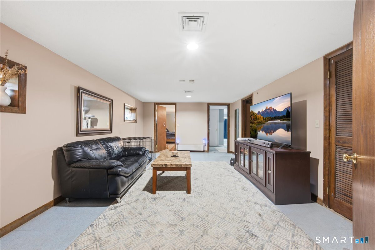 110 Butlertown Road Waterford, CT 06385 - Photo 21 of 35 a living room with furniture and a flat screen tv