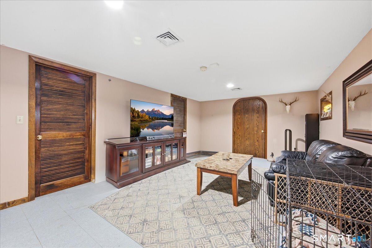 110 Butlertown Road Waterford, CT 06385 - Photo 22 of 35 a living room with furniture a flat screen tv and kitchen view