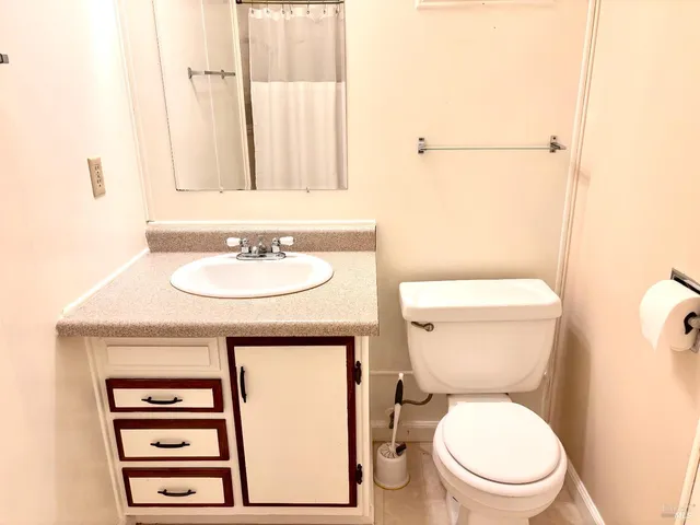 a bathroom with a toilet a sink and a mirror