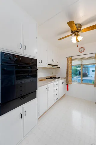 a kitchen with granite countertop white cabinets and white appliances