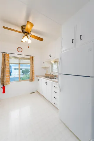 a kitchen with stainless steel appliances white cabinets and a refrigerator