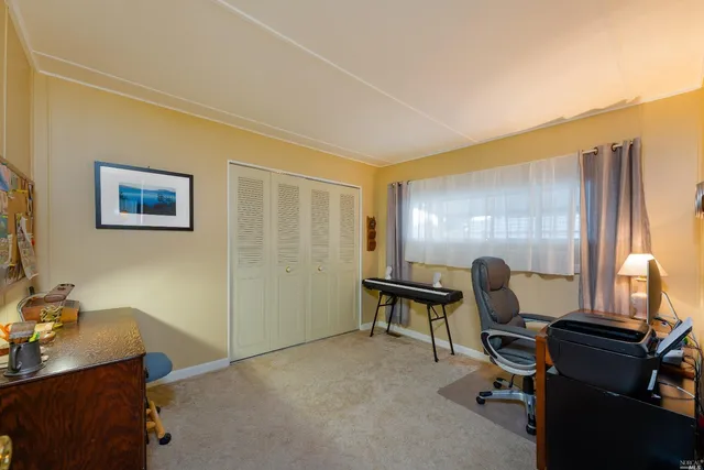 a view of a workspace with furniture and a window
